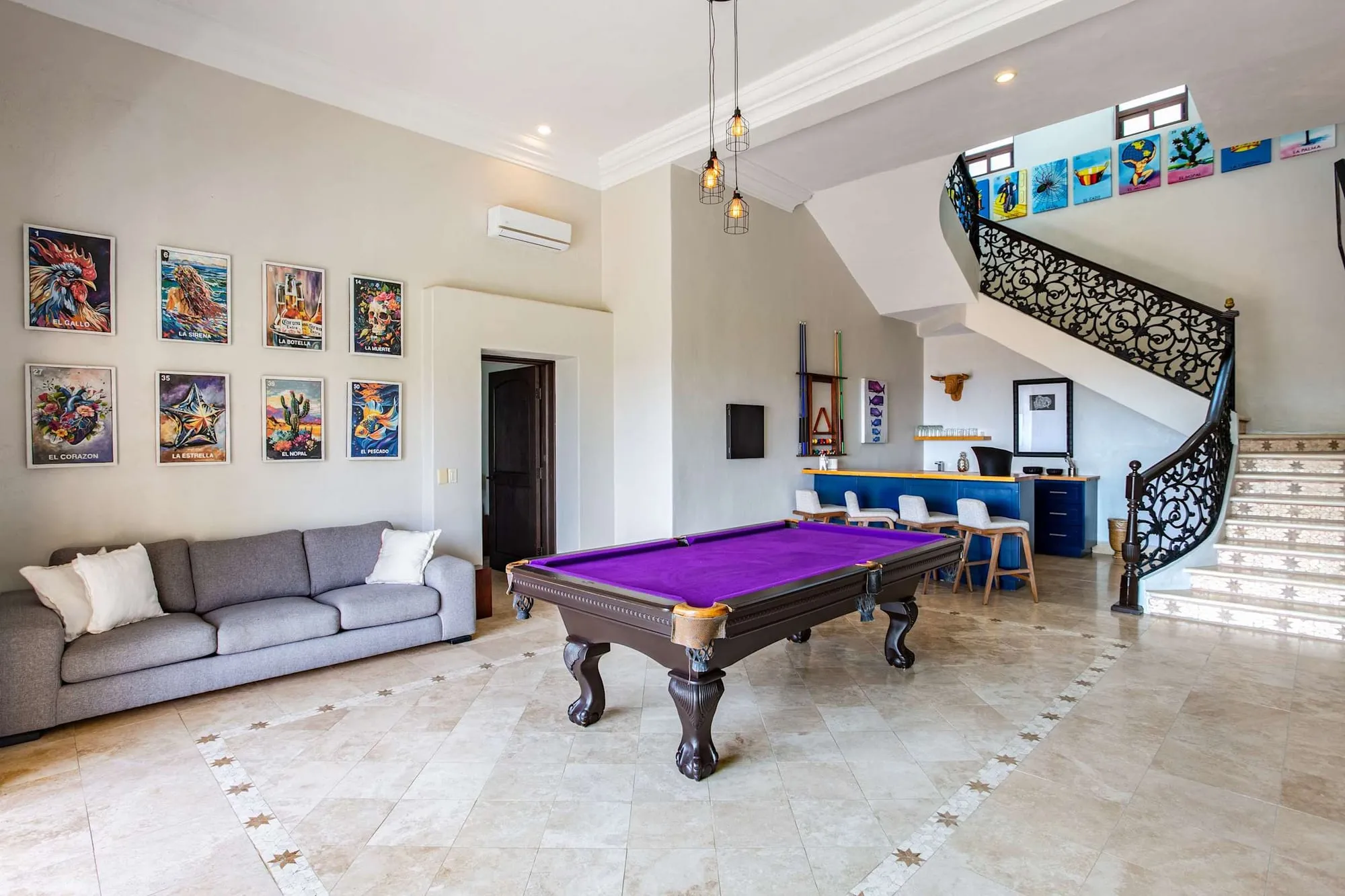 The game room with a pool table, beside the stair to the upper level