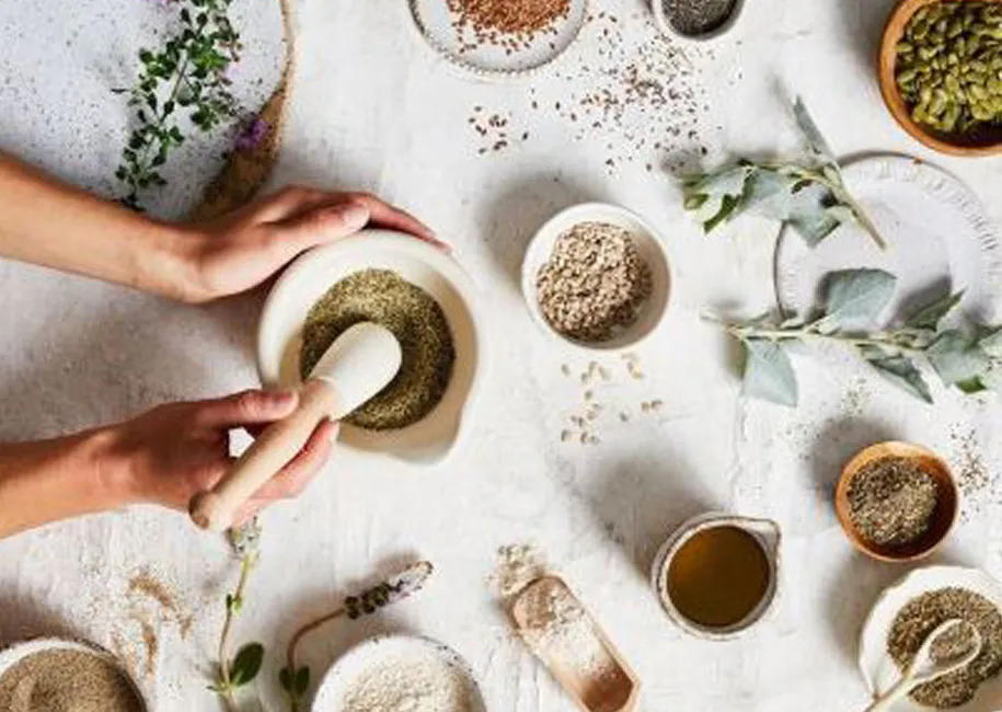 Herbs, seeds and a stone mortar laid out for a ceremony