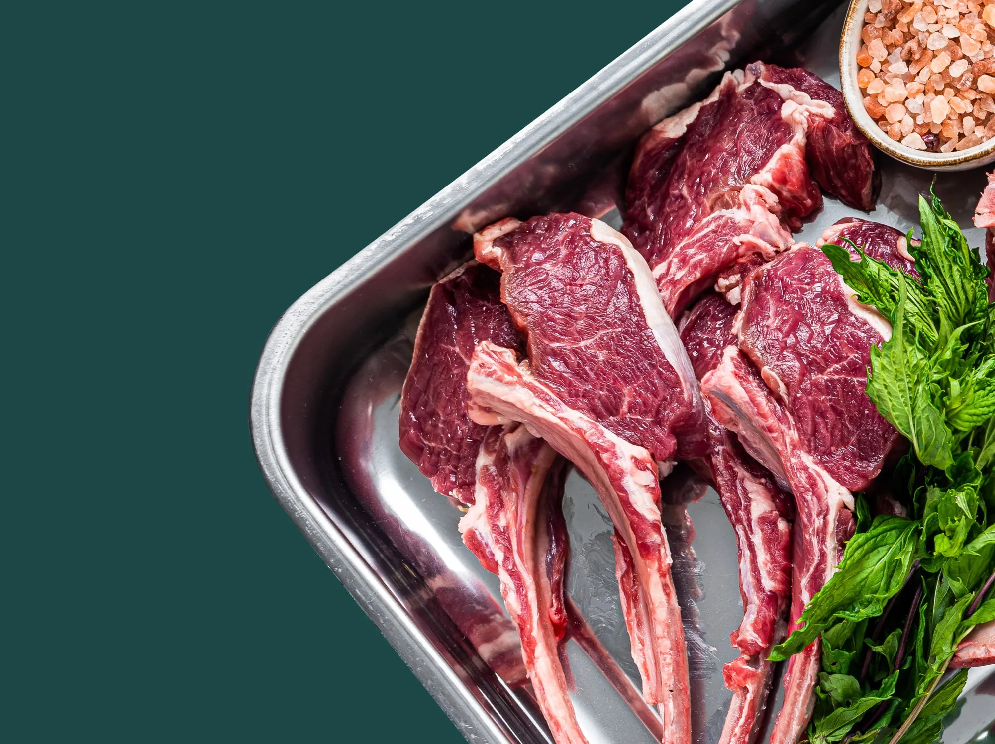 Frenched lamb racks in a steel tray, ready for portioning