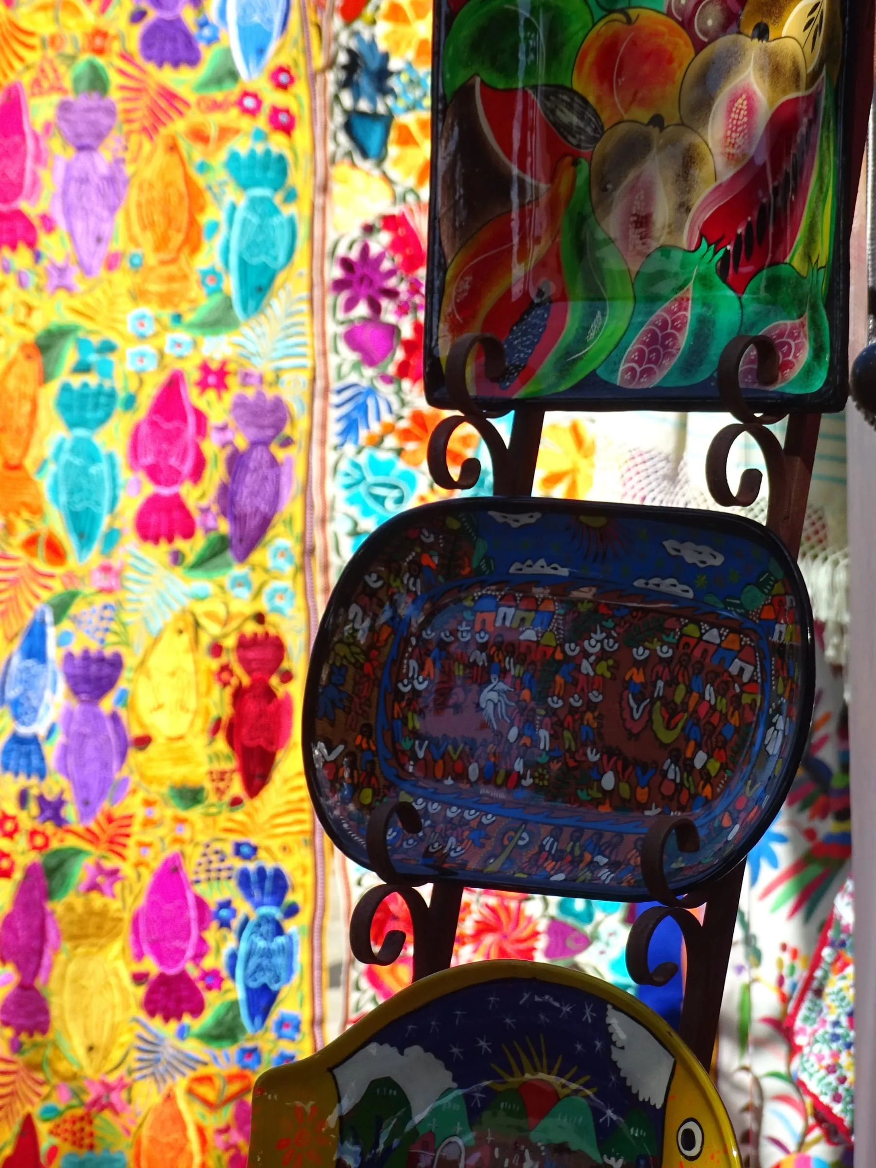 Hand-painted crafts hanging at a street stall in San José del Cabo